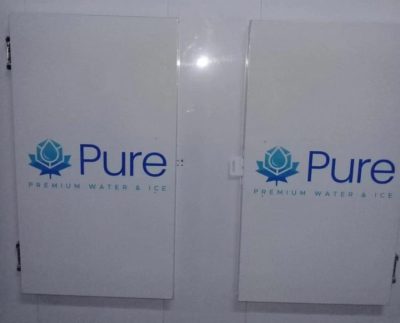 Deux grandes portes blanches sur lesquelles sont inscrites en gros « Pure » et en plus petit « Premium Water and Ice ».