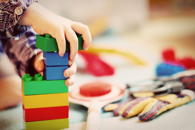 Des petites mains d'enfants jouent avec des blocs de couleurs.