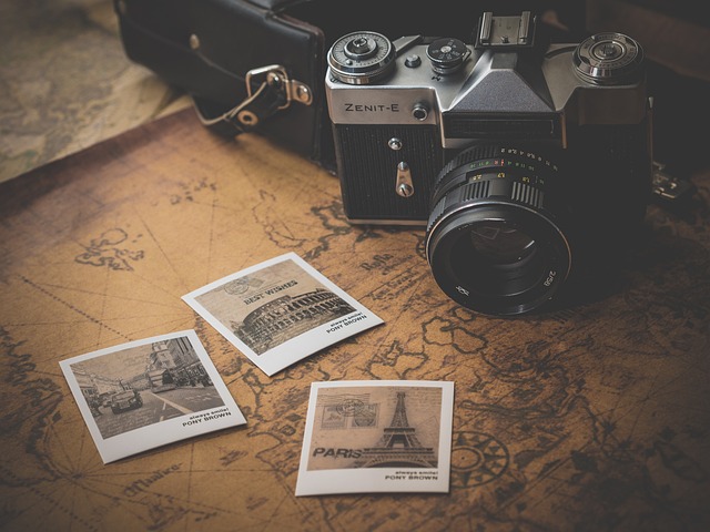 Une caméra photo et trois polaroids sont installés sur une carte du monde jaunis.