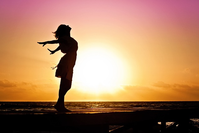 La silhouette d'une femme devant un coucher de soleil.